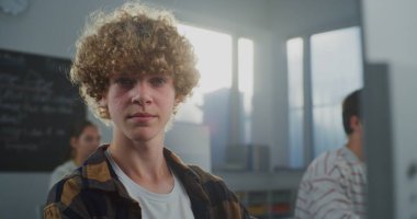 Sınıfta Genç Kıvırcık Saçlı Öğrenci Oyun Geliştirme Çalışmaları 'nın kapanışı. Geleceğin Geliştiricisi Kodlama ve Tasarım, Kameraya Bakıyor. Kariyer becerileri kavramı, Yaratıcı Eğitim. Portre.