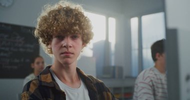 Sınıfta Genç Kıvırcık Saçlı Öğrenci Oyun Geliştirme Çalışmaları 'nın kapanışı. Geleceğin Geliştiricisi Kodlama ve Tasarım, Kameraya Bakıyor. Kariyer becerileri kavramı, Yaratıcı Eğitim. Portre.