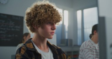 Sınıfta Genç Kıvırcık Saçlı Öğrenci Oyun Geliştirme Çalışmaları 'nın kapanışı. Geleceğin Geliştiricisi Kodlama ve Tasarım, Kameraya Bakıyor. Kariyer becerileri kavramı, Yaratıcı Eğitim. Portre.