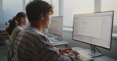 Parlak Üniversite Sınıfı 'nda Gençler Eğitim Programı. Öğrenciler Bilgisayar Monitörler, Takım Çalışması, Yazılım Geliştirme ve Gelecek İçin Temel Dijital Yetenekler Üzerine Kod Yazıyorlar. Sabit Çekim.