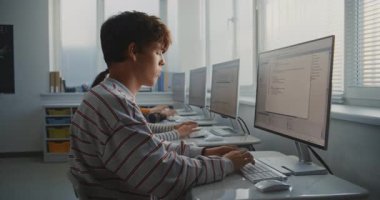 Öğrencilerin Bilgisayar Üzerine Kodladığı Üniversite Sınıfı. Çizgili Gömlekli Genç Adam Oyun Geliştirme Projesi için Ekrana Odaklandı. Dijital Eğitim kavramı, takım çalışması. Doli Vuruşu