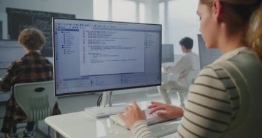 Enstitü Uygulamalı Kodlama Projesi 'ndeki kız. Dev Atölyesi 'nde, Genç Kadın Monitörde Daktilo Programı Kodu. Modern Eğitim, Bilgisayar Bilimi Öğrenimi, Gelecek Teknoloji Becerileri kavramları.