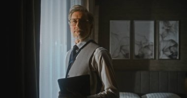 Sunum için Sunucu Sunny Otel Odasında. Kendine güveni tam bir işadamı, elinde dijital tabletle pencerenin önünde toplanmaya hazır bekliyor. Profesyonel Eğitim, Dijital Çalışma Akışı. Portre.