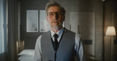 Yelek ve Kravat Giyen Gri Saçlı Adam, Dijital Tablet veya İnce Dizüstü Bilgisayarlı Ellere Bakıyor. Uzaktan Yönetim, Dijital Profesyonellik, Mobil Teknoloji, İş Seyahati. Portre.