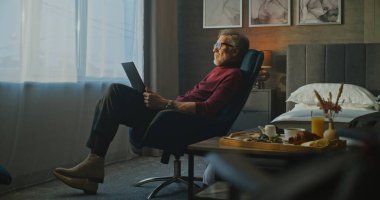 Odaklanmış İşadamı, otel odasının Sabah Işığı 'nda dizüstü bilgisayarda çalışıyor. 