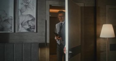 Tarz sahibi adam sunum işi konferansından sonra otel odasına girer. Olgun Adam Konferans Rozeti Giyen Adam Dijital Tablet 'e giriyor. Konseptler, iş konferansları, iş gezileri. Portre.