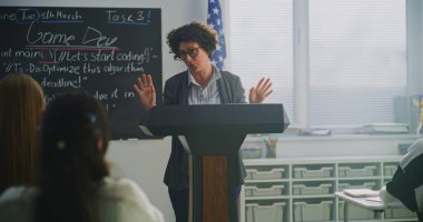 Hevesli Gülümseyen Kadın İnteraktif Sınıflar Arasında Öğrencileri Açıklıyor. Yenilikçi ABD Eğitim Sistemi, Etkin Öğrenim, Öğrenci Katılımı, İletişim Temelli Öğretim.