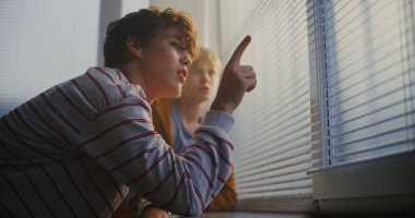 Erkek Öğrenciler Pencere eşiğine yaslanarak, Panjurlar Arasında Sessizce Sohbet Ettiler. Akranlar Arasında Dostluk Bağlantısı, Hayal kurmak ve Düşünceli İletişim.