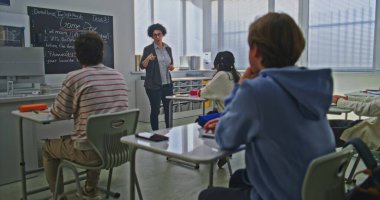 Kadın Öğretmen, Parlak Sınıftaki Öğrenci Grubu 'na Kodlama Görevini Açıklayan Tahta Yakınında Duruyor. Okul ortamında Modern Eğitim, Etkileşimli Öğrenme, Yaratıcı Takım Çalışması Konsepti.