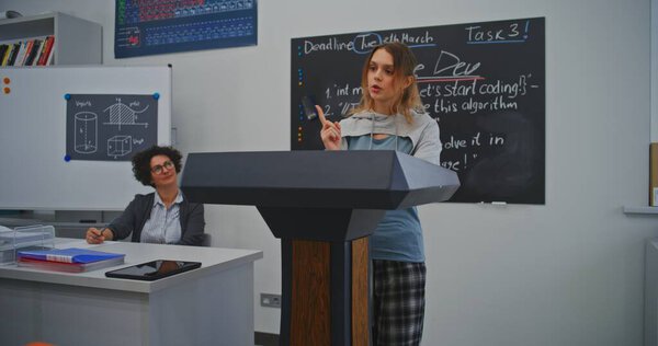 Энергетическая студентка представляет результаты исследований своим сверстникам в светлом зале. Концепция активного обучения, вовлечения студентов и развития эффективных навыков публичной речи. Долли Шот.