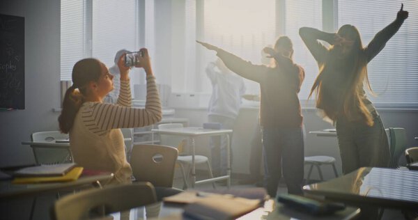 Girl Films Two Female Classmates Smiling and Performing Trendy Dance Moves on Smartphone. Concept of Digital Generation, Teamwork, Joyful Interaction Between Students and TikTok Trend. Static Shot.