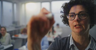 Gözlüklü Yetişkin Kadın Görünmez Etkileşimli Tahtaya Kalemle Yazıyor. Öğrenciler dikkatle dinleyin. Modern Öğretim Yöntemleri kavramı, Eğitim Teknolojisinde Yenilikler.