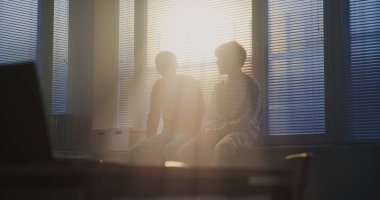 Öğrenciler Pencere kenarında yan yana oturur, Perdelerin arasından Gün Işığı 'na doğru süzülmeye başlarlar. Bir jest konuşur, diğeri de dikkatlice dinler. Kavramsal Gençlik Yansıması ve Arkadaşlığı.