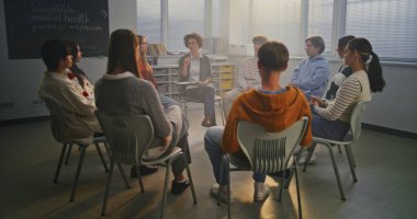 Bayan öğretmen zihinsel sağlık farkındalığıyla ilgili öğrencilerle açık tartışmayı yönetiyor. Kadın Öğrencileri Paylaşım Duygularını Güvenli, Destekleyici Sınıflar Ortamına Destekliyor. Duygusal Zeka kavramı.