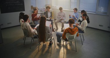 Öğretmen, Psikolojik Durum Öğrencileri Yönetiyor. Öğrenciler, öğretmenlerinin rehberliğinde düşüncelerini paylaşıyor, psikolojiyi tartışıyorlar. Açık İletişim, Ruh Sağlığı Eğitimi ve Sosyal Duygusal Öğrenim.