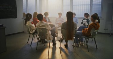 Çeşitli Öğrenci Grubu Şefkatli Öğretmen 'in Akıl Sağlığı Rehberi Konulu Sınıf Konuşmasına Katılır. Konsept Empati, Açık İletişim ve Eğitimde Psikolojik Güvenlik. Yavaş Hareket.