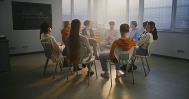 Genç öğrenciler, İlgili Öğretmenler ile Çemberde oturup Psikoloji ve Öz-Farkındalık 'ı tartışıyorlar. Modern Okullarda Öğrenci Refahı, Farkındalık ve Duygusal Desteğin Önemi. Yavaş Hareket.