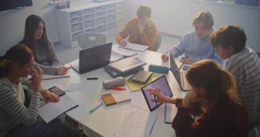 Konsantre Öğrenciler Paylaşılan Masa Etrafında İşbirliği Yapar, Dijital Araçlar ve El Yazıları Birleştirir. Modern Sınıflar Arasında Takım Çalışması, Yaratıcı Sorun Çözme ve Harmanlanmış Öğrenme Konsepti.