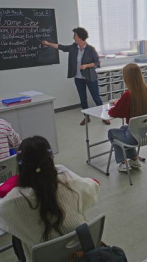 Oyun Geliştirme Konferansı sırasında Öğretmen, konuyu ve soruları açıklıyor. Öğrenciler el kaldırsın, hazır cevap. Modern Eğitim, Etkileşimli Öğrenme ve BTMM Eğitimi kavramı. Dikey Çekim.