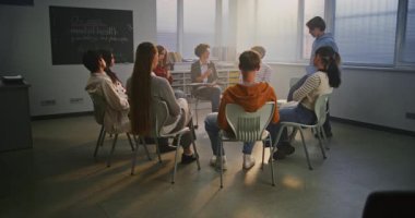 Genç öğrenciler, İlgili Öğretmenler ile Çemberde oturup Psikoloji ve Öz-Farkındalık 'ı tartışıyorlar. Modern Okullarda Öğrenci Refahı, Farkındalık ve Duygusal Desteğin Önemi. Yavaş Hareket.
