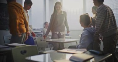 Neşeli Kız ve Erkek Bilek Güreşleri Sınıfı Masasında Neşeli Güreş, Gülen Arkadaşlarla çevrili. Öğrenciler arasında cinsiyet eşitliği, duygusal açıklık ve olumlu iletişim kavramı. Sabit Çekim.