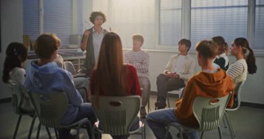 Çemberin Ortası 'ndaki Genç Kıza Duygusal Doğaçlama Egzersizi, Gerçek Hayat Duygularını ve Empatiyi Keşfeden Kadın Öğretmenler Rehberi. Eğitim ve Duygusal Zeka Konsepti.