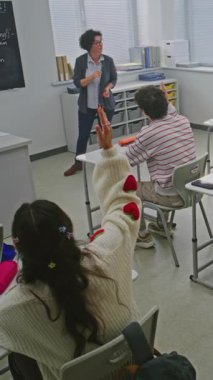 Programlama sınıfındaki Bayan Öğretmen Öğrenciyi Kuralları Düzeltmek İçin Karatahtaya Çağırıyor. Modern Sınıfta Kodlamayı Öğrenme. Yetenek gelişimi kavramı, modern eğitim. Dikey Çekim.