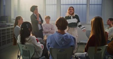 Grubun Ortasında Duran Öğrenci Kız Öğretmen Gözetimi Altındaki Kişisel Duygular Üzerine Uygulamalı Doğaçlama Yapıyor. Konsept Drama Terapisi, Duygusal İfade ve Ruh Sağlığı Eğitimi.