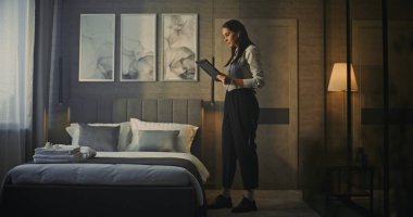 Profesyonel Kadın Modern, Lüks Otel Odasına Girdi. Tableti Elde Tutma, Kadın Araştırmaları Odası, Konfor ve Ayarlama Yatağı. Otel Yönetimi, İş Seyahati, Üst Düzey Müşteri Hizmetleri.