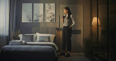 Profesyonel Kadın Modern, Lüks Otel Odasına Girdi. Tableti Elde Tutma, Kadın Araştırmaları Odası, Konfor ve Ayarlama Yatağı. Otel Yönetimi, İş Seyahati, Üst Düzey Müşteri Hizmetleri.