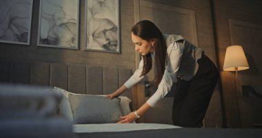 Oda Temizlikçisi Üniformalı Kadın, Yeni Misafir Odası Hazırlanırken Yatak ve Yastık Yerleştirmesini Ayarlıyor. Organize Çalışma Akışı, Temizlik, Yüksek Kalite Hizmet. El bilgisayarı.