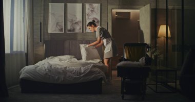 Hizmetçi Vagonu Misafirler gittikten sonra altını değiştiriyor. Sakin, Hassas Hareketler, Taze Düzen ve Temizlik. Lüks Otel Oda Servisi İş Akımında Profesyonel Rutin kavramı.