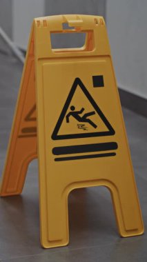 Otel Koridoru Temizleme Devam Ediyor. Hizmetçi Parlak Sarı Uyarı İşareti Yanı başındayken Yerleri Dikkatle Siler Yüzey Kayganlığını Belirtir. Misafirperverlik Standartları, Detaylara Dikkat. Dikey Çekim.