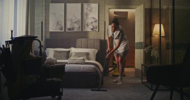 Profesyonel Otel Temizlikçisi, Modern Misafir Odası. Üniformalı Kadın Carpet Zemini Temizler, Kusursuz ve Karşılama Alanını Güvence Eder. Konukseverlik, Oda Hazırlığı, Temizlik.