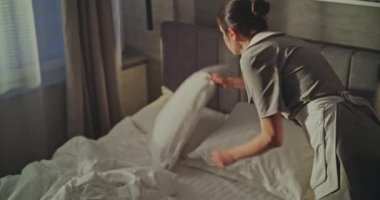 Temizlikçi, çıkış yaptıktan sonra yatağı kaldırır ve çamaşırları arabaya koyar. Organize Ekipmanlı Temiz Üniformalı Kadın İç İşleri 'nde çalışıyor. Mesleki Misafirperverlik ve Konuk Hazırlığı kavramını kabul et.