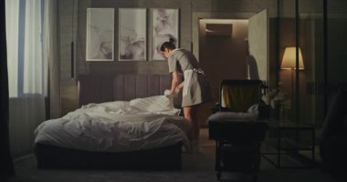 Hizmetçi Vagonu Misafirler gittikten sonra altını değiştiriyor. Sakin, Hassas Hareketler, Taze Düzen ve Temizlik. Lüks Otel Oda Servisi İş Akımında Profesyonel Rutin kavramı.