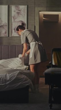 Hizmetçi Vagonu Misafirler gittikten sonra altını değiştiriyor. Sakin, Hassas Hareketler, Taze Düzen ve Temizlik. Lüks Otel Oda Servisi İş Akımında Profesyonel Rutin kavramı