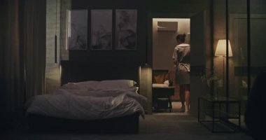 Temiz üniformalı bir kadın, temizlik arabasıyla odaya girer, misafir çıkış yaptıktan sonra kullanılmış çarşafları çıkartır. Hizmetçi çarşaf katlar, çarşafları çamaşır arabasına yerleştirir, yeni gelenlere hazırlanma odası. Sabit Çekim.