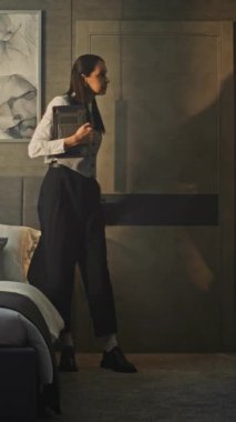 Profesyonel Kadın Lüks Otel Odasına Girdi. Tableti Elde Tutma, Kadın Araştırma Odası, Amenities, Ayarlama Yatağı. Otel yönetimi, iş seyahati, üst düzey müşteri hizmetleri. Dikey Çekim.