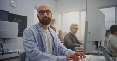 Bilgisayar Laboratuvarındaki Sakallı Olgun Adam Programlama Dersine Katılıyor. Odaklanmış ama Rahatlamış İfade Özgüven ve Motivasyonu Yansıtır. Sürekli Öğrenme, Teknoloji Becerileri ve Büyüme kavramını benimse. Portre.