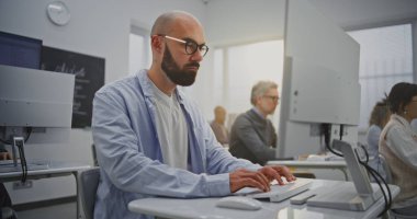 Bilgisayar Laboratuvarındaki Sakallı Olgun Adam Programlama Dersine Katılıyor. Odaklanmış ama Rahatlamış İfade Özgüven ve Motivasyonu Yansıtır. Sürekli Öğrenme, Teknoloji Becerileri ve Büyüme kavramını benimse. Portre.