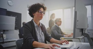 Kırklı yaşlarının ortasındaki koyu renk saçlı kadın IT dersinde Monitor Kodlama 'da oturuyor. Yetişkinler için Modern Eğitim, Yetenek Büyümesi ve Yaşam Boyu Öğrenme Ortamı 'nda Teknoloji Güçlendirmesi kavramını benimseyin. Portre.