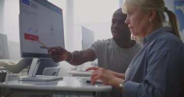 Genç Afrikalı Amerikalı Eğitmen Yapay Zeka Görüntü Üretim Sürecini Yaratıcı Teknoloji Dersinde Kıdemli Bayan Öğrenciyi Açıkladı. Yaşam Boyu Öğrenme, Dijital Eklenti, Nesiller Arası Eğitim kavramı.