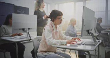 Kıvırcık Saçlı Zarif Bayan Öğretmen, Yetişkin Öğrencilerle Yetişkin Bilişim Sınıfı 'nda Kodlama Projeleri İnceledi. Eğitimde Dijital Dönüşüm, Destek ve Takım Çalışması kavramını benimse.