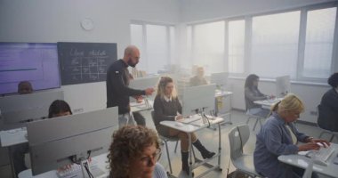 Çeşitli Olgun Öğrenciler, Parlak Bilgisayar Sınıfı 'nda Erkek Öğretmenler Yönetiminde Dijital Yetenekler Uygular. Inclusion, Upskilling, Sürekli Öğrenme ve Dijital Güçlendirme. Yüksek Açı.