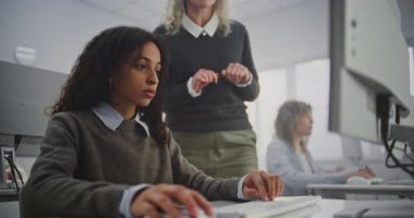 Modern Bilgisayar Sınıfında Dolaşan, Yetişkin Öğrencilere Programlama Atölyesinde Rehber Olgun Bayan Öğretmen. Hata Ayıklama Kodunu Açıklar, Mantığı Açıklar ve Destekçiler Öğrenme Atmosferinden Güvenilir.