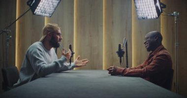 Modern Podcast Stüdyosunda İki Erkek Kayıt Etme Sohbeti. Yetişkin Erkekler Masanın karşısında Açık, Etkileyici Sohbet Etmek İçin Otururlar. İletişim, Yaratıcılık ve Otantik Diyalog kavramı.