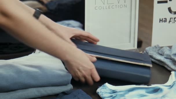 The girl at the counter selects a handbag — Stock Video