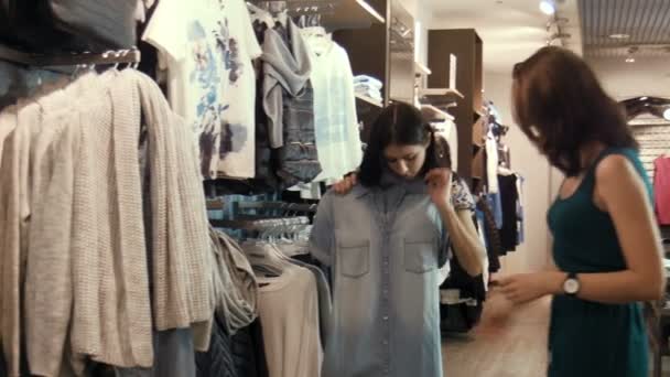 Девушка выбирает джинсовое платье — стоковое видео