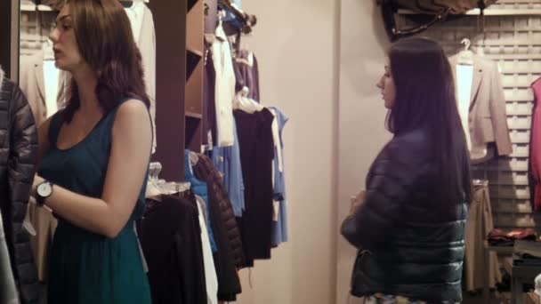 Het meisje probeert op een donker blauwe jas — Stockvideo